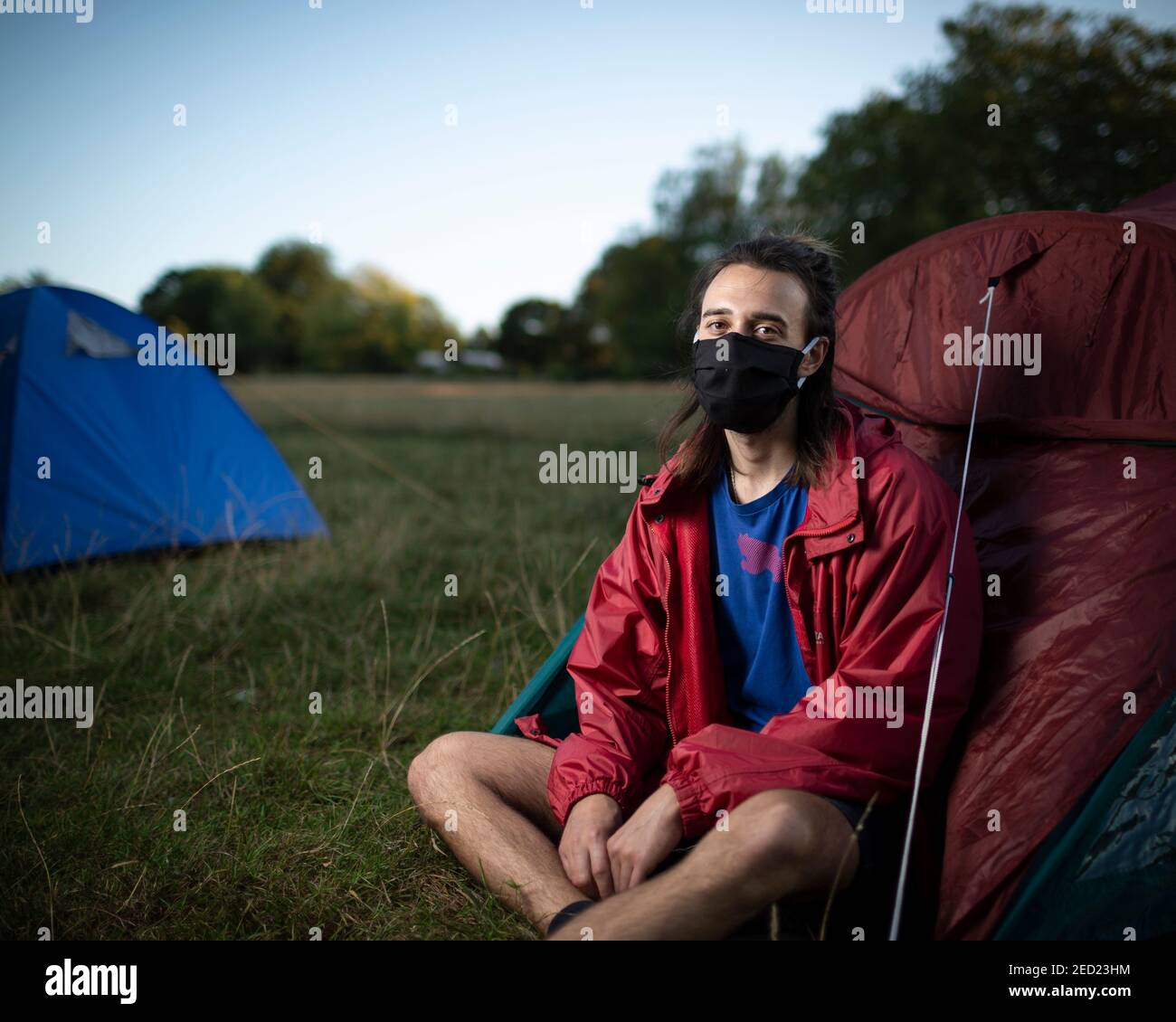A male activist from Extinction Rebellion sits outside his tent at a campsite in Brockwell Park, London, 31 August 2020 Stock Photo