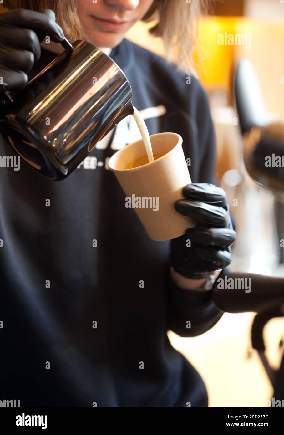 barista pouring milk from pitcher into paper cup, take away coffee ...
