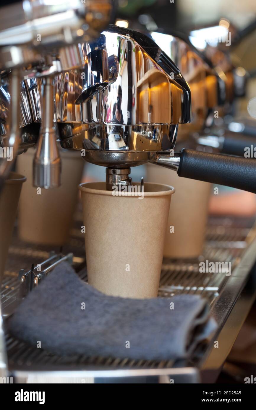 closeup of modern professional espresso machine in coffee shop with coffee pouring into take away paper cup, nobody Stock Photo
