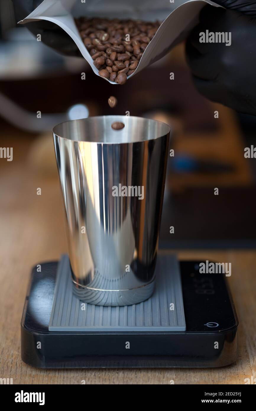 weighing coffee beans on black acaia scales in coffee shop, no people Stock Photo