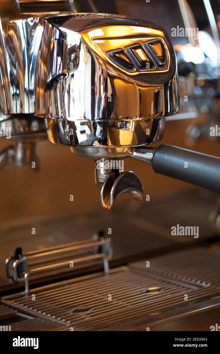 closeup of holder with beautiful black handle in professional espresso coffee machine group head, no people Stock Photo