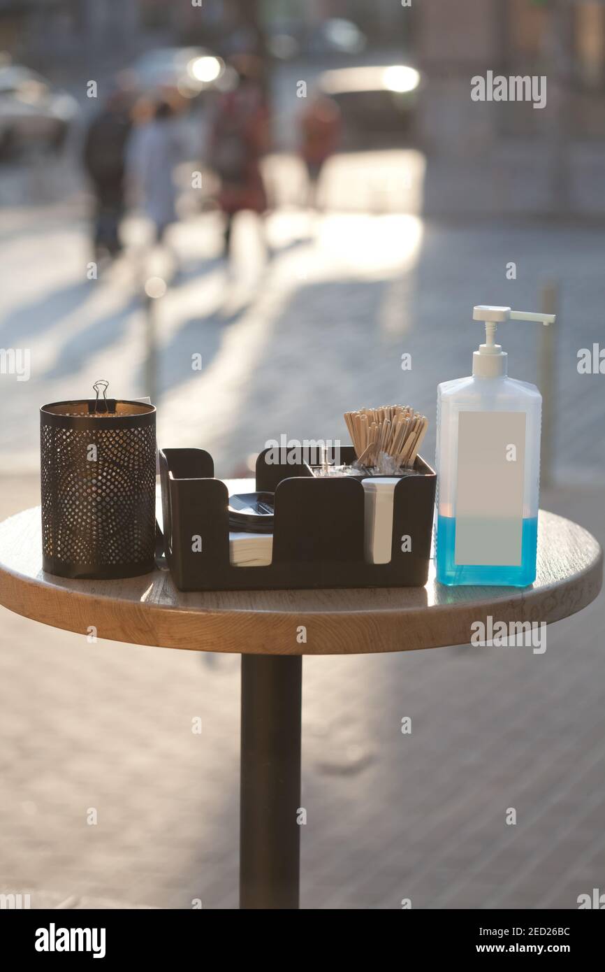 safety measures during covid 19 quarantine - table with sanitizer in public place in front of coffee shop Stock Photo