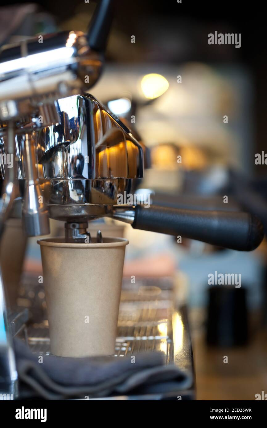 closeup of coffee pouring from spouts into take away paper cup in espresso machine double holder, nobody Stock Photo