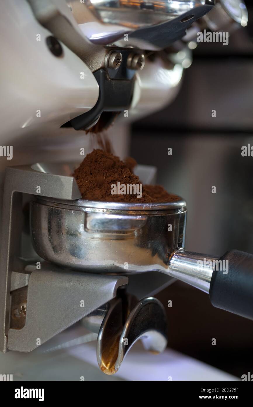 closeup of coffee grinding into holder, in modern grinder, nobody Stock Photo