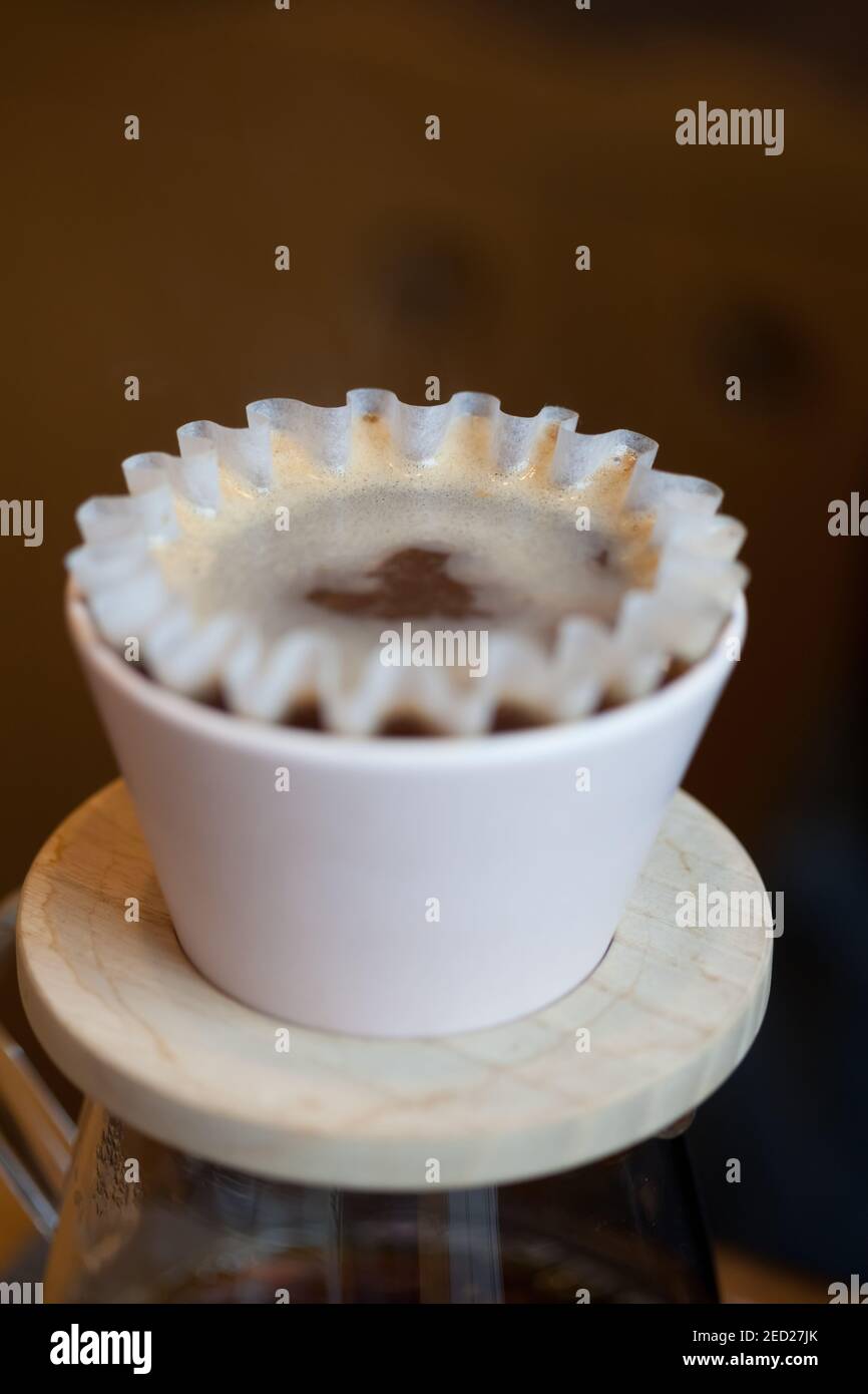kalita with paper filter with water druing coffee brewing process, closeup Stock Photo