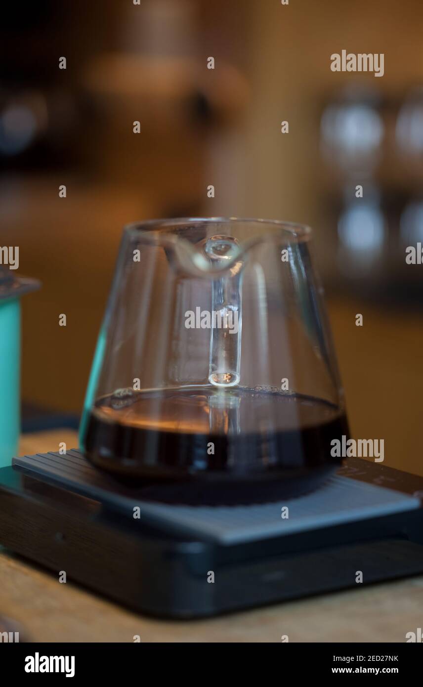 glass server with black coffee on digital scales, closeup with blurred background Stock Photo