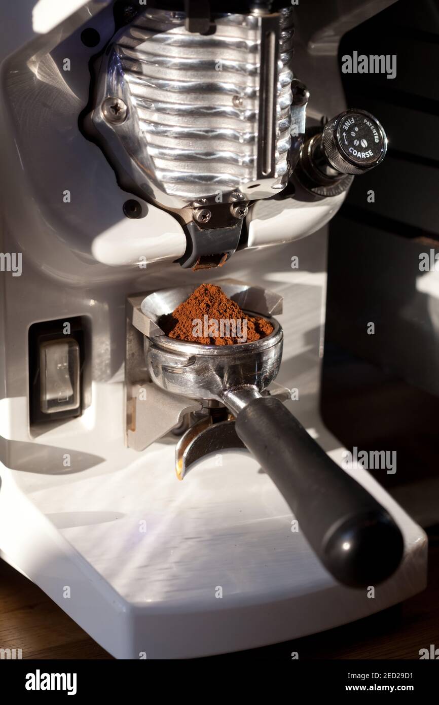 closeup of coffee grinding into holder, in modern grinder, nobody Stock Photo
