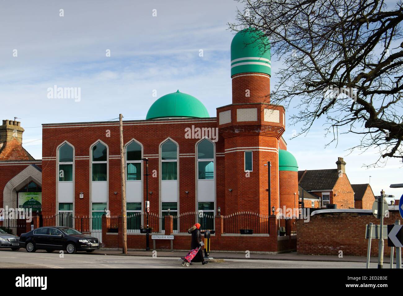 Jameh Masjid Gulshan-e-Bagdhad Mosque at Queens Park, Bedford - a muslim lady walks past the place of worship at Bedford, Bedfordshire, England, UK Stock Photo