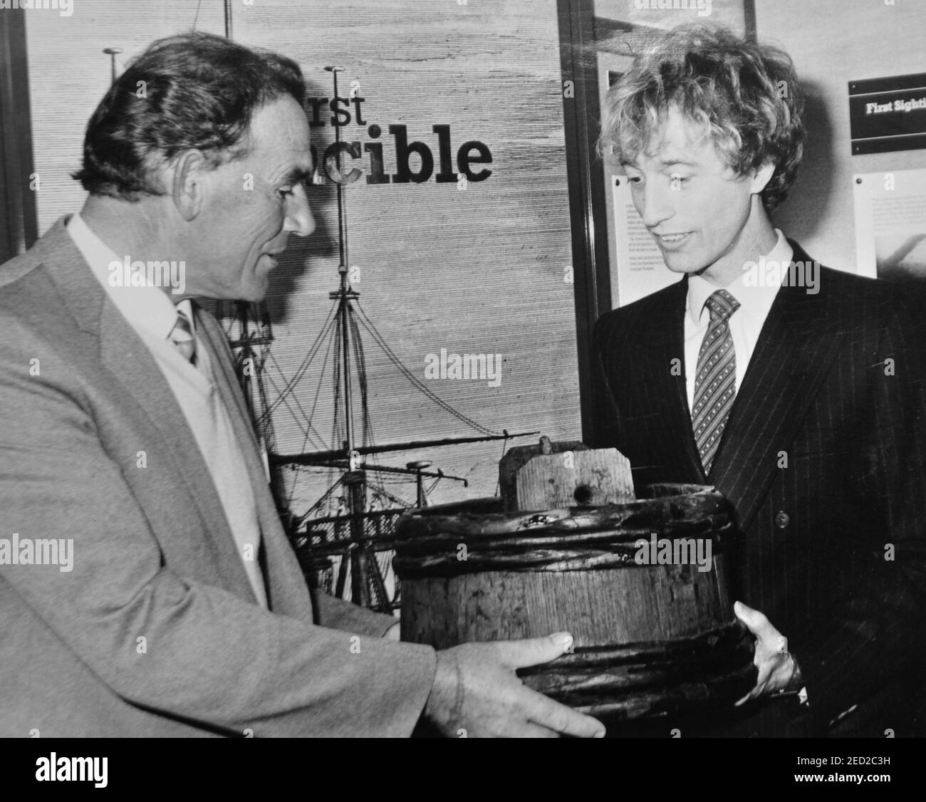 POP STAR ROBIN GIBB OF THE BEE GEES WITH FISHERMAN ARTHUR MACK WHO FOUND THE WRECK OF THE FIRST HMS INVINCIBLE, WHICH SANK IN 1758, LOOK AT A ''SPIT KID'' ONE OF THE RELICS DISCOVERED BY DIVERS OFF PORTSMOUTH, HANTS,1984 Stock Photo