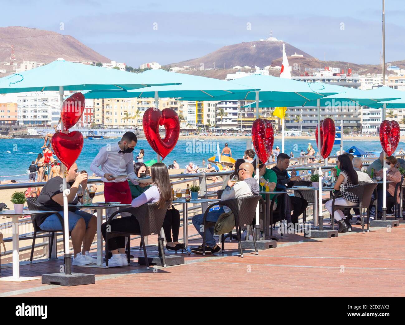 Las Palmas, Gran Canaria, Canary Islands, Spain. 14th February, 2021. St Valentine's Day lunch in glorious sunshine overlooking the city beach in Las Palmas on Gran Canaria. Credit: Alan Dawson/Alamy Live News. Stock Photo