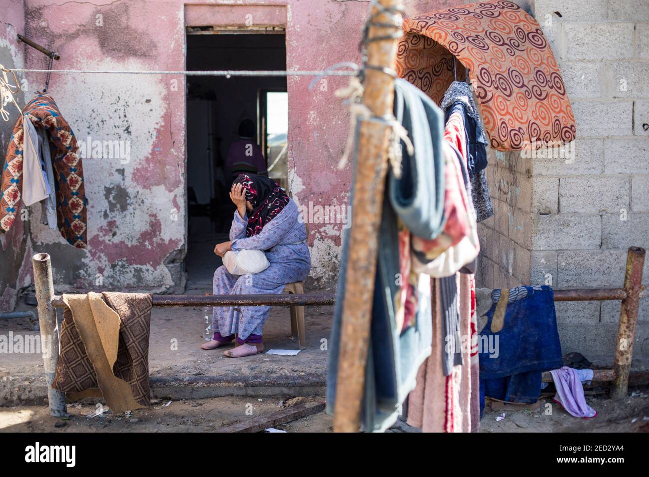 A Palestinian woman sits outside her home at the Beach camp in the ...