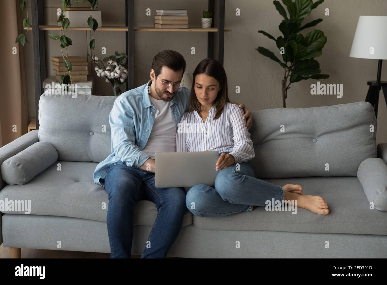 Serious young couple holding laptop consider on wedding planning Stock Photo