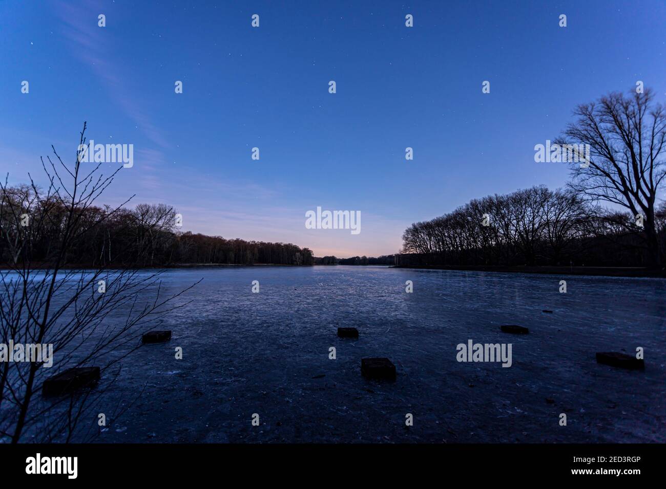 frozen ice surface of Decksteiner Weiher lake in Cologne at sunrise Stock Photo