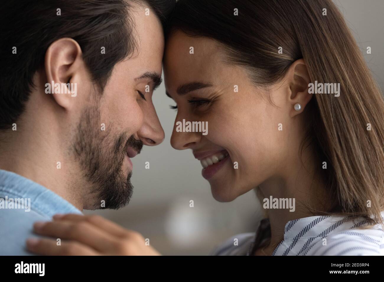 Affectionate couple in love embrace touch foreheads express tender feelings Stock Photo