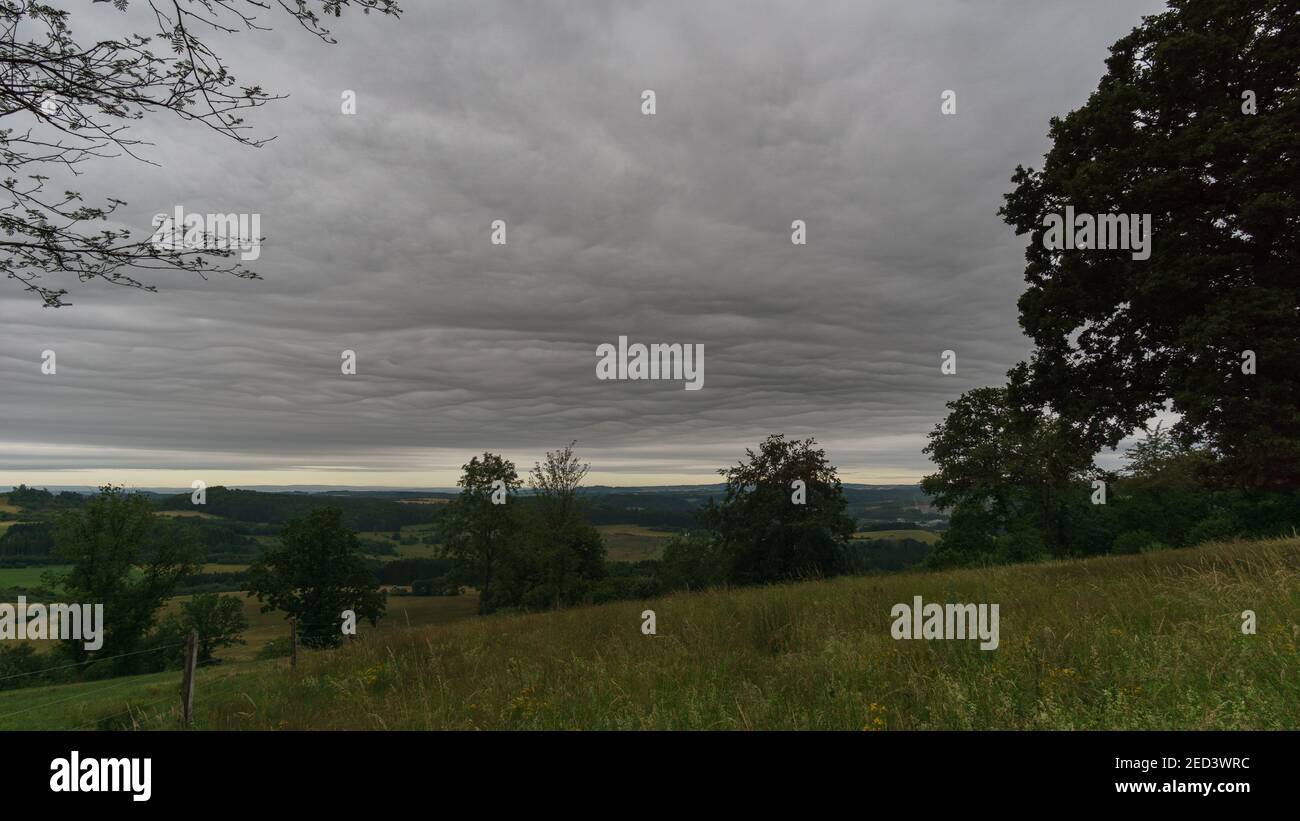 dark structured clouds over eifel landscape in the morning, Germany Stock Photo