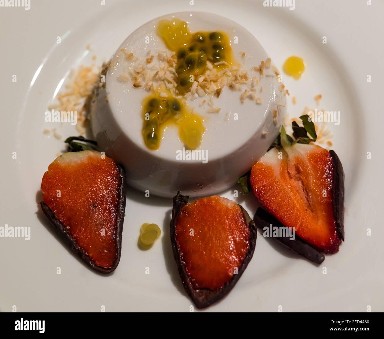 Fine dining dessert plate: coconut panna cotta, passionfruit, pineapple gel and chocolate dipped strawberries by chef Paul Wedgwood, Scotland, UK Stock Photo