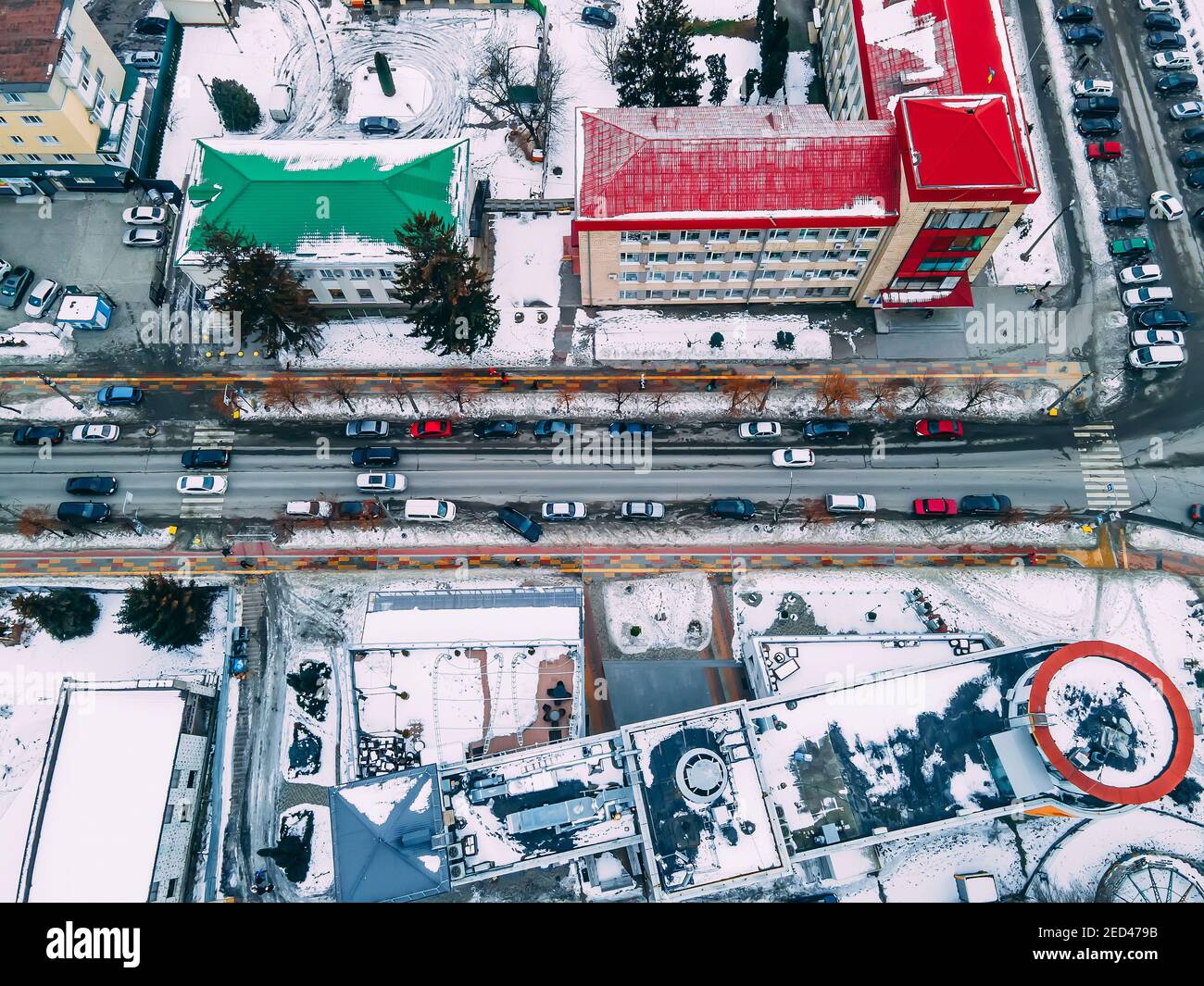 Aerial top down view of road in small european city with snow covered roofs at winter cloudy day Stock Photo