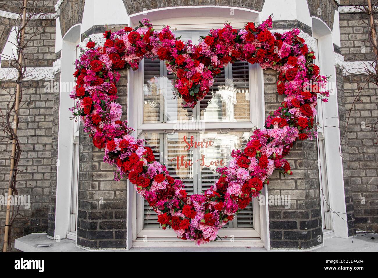Beautiful flowers in a heart shape surround the words 'Share the love' Stock Photo
