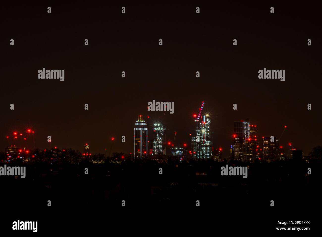 Cranes and high rise buildings including St Georges Tower on a London skyline at night Stock Photo