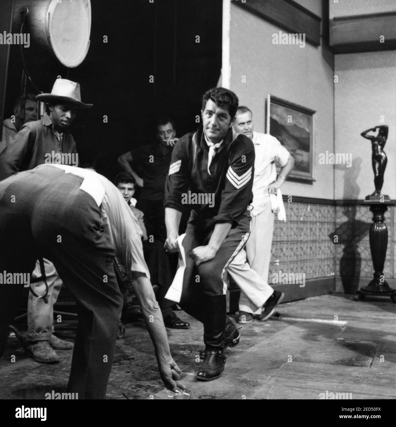 DEAN MARTIN rehearses fight scene while SAMMY DAVIS Jr's Double and FRANK SINATRA Jr (seated) look on candid on set during filming of SERGEANTS 3 / SERGEANTS THREE 1962 director JOHN STURGES Essex Productions / Meadway-Claude Productions Company / United Artists Stock Photo