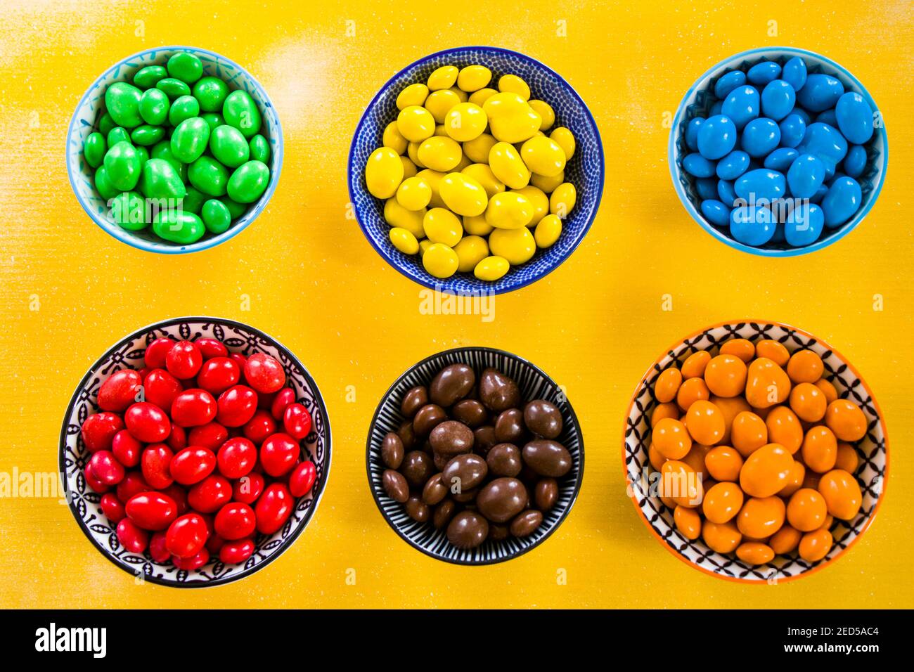 M&M's candy on the yellow background in bowls, colorful candy and ...