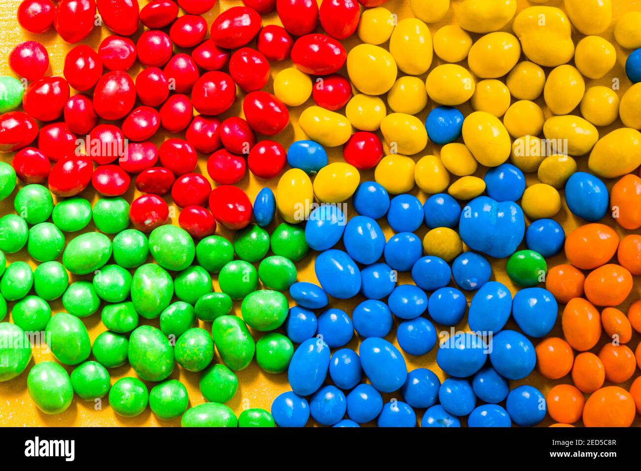 M&M's candy on the yellow background, colorful candy and multicolored ...