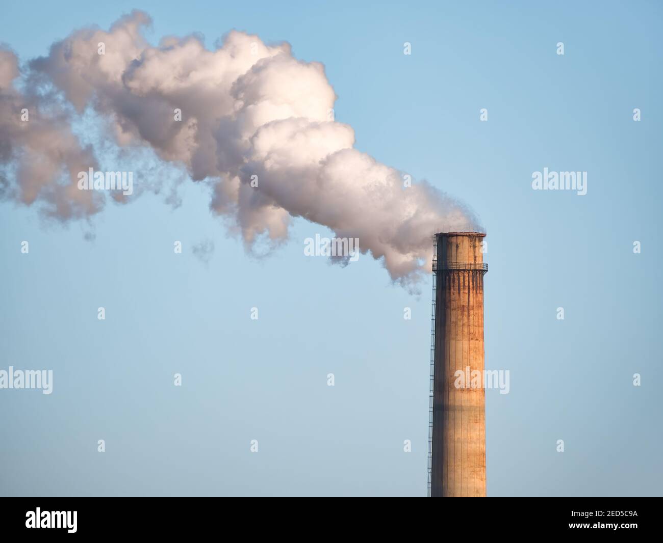 Dense smoke and steam coming out from the industrial chimney