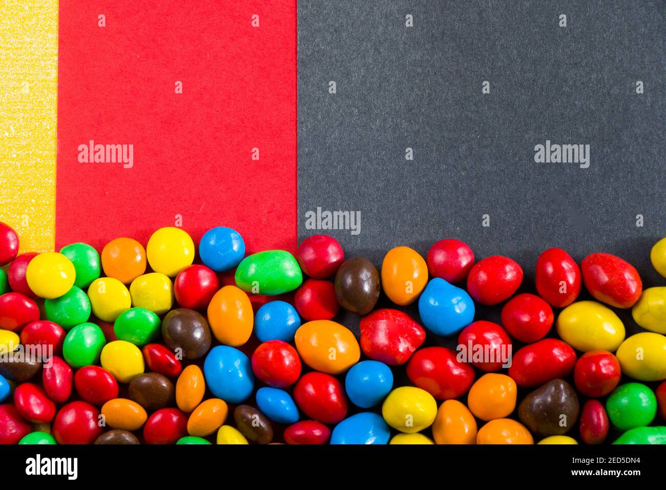 M&M's candy on the red, black and yellow background, colorful candy and ...