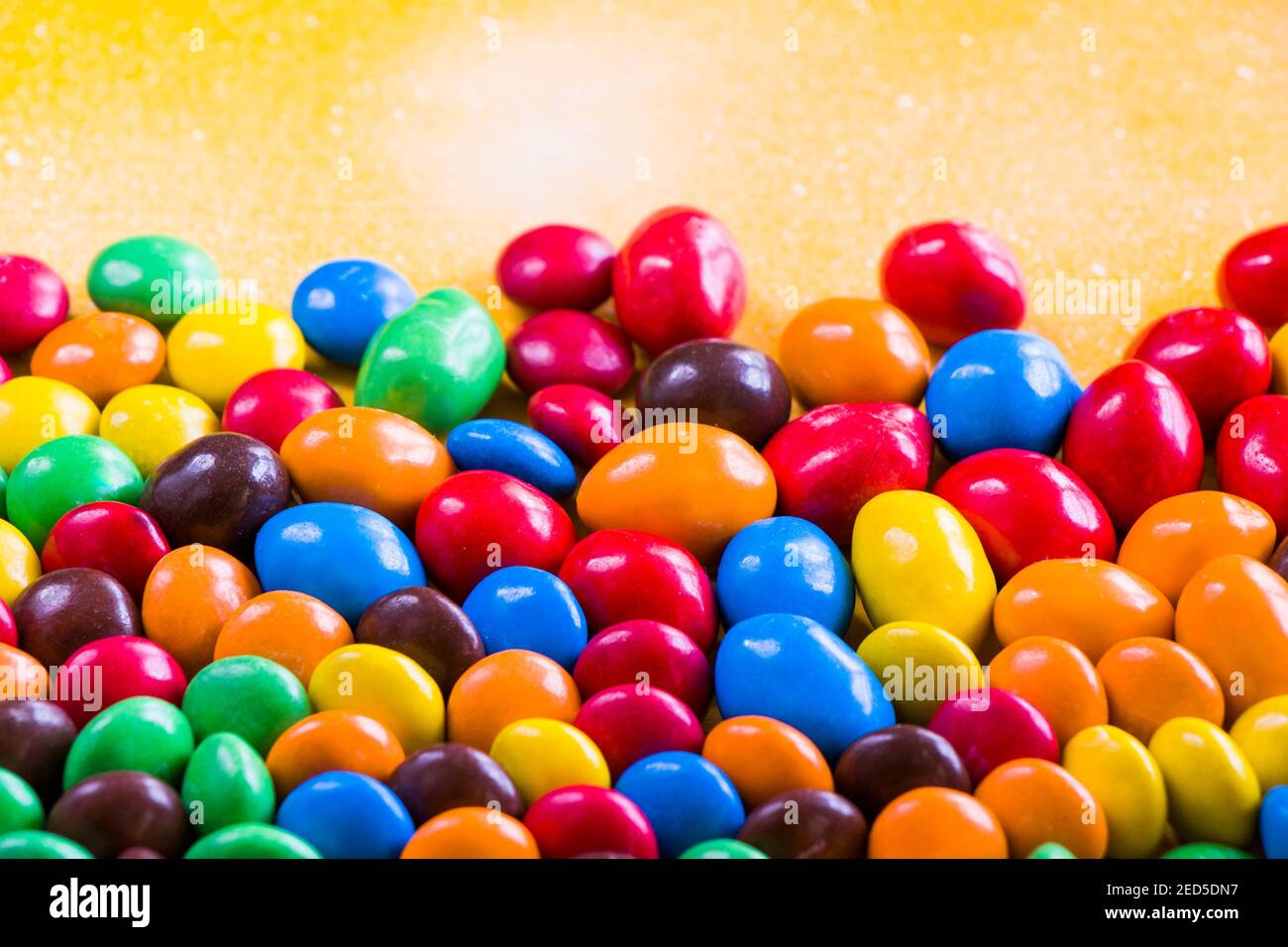 M&M's candy on the yellow background, colorful candy and multicolored ...