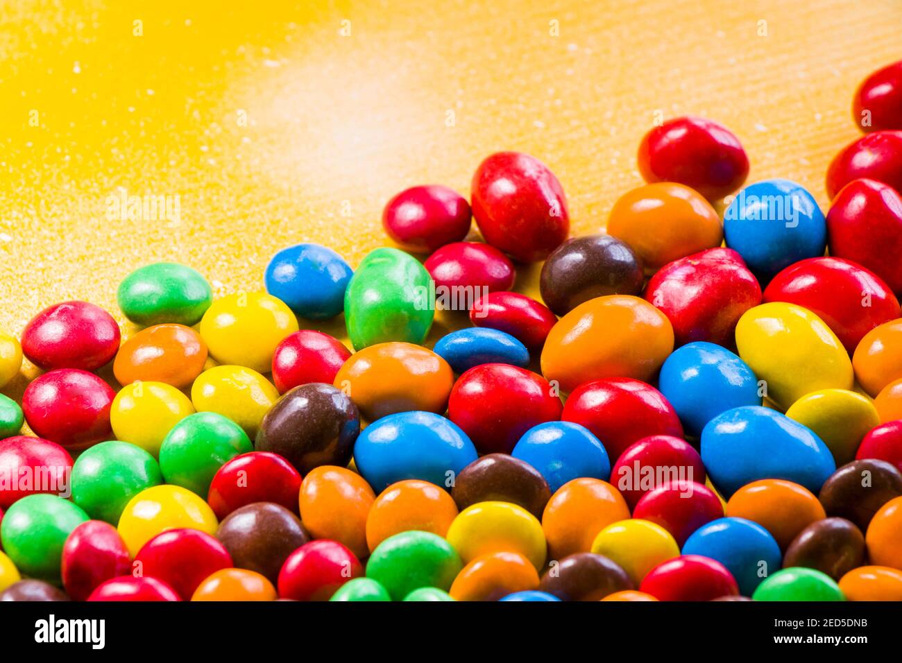 M&M's candy on the yellow background, colorful candy and multicolored ...