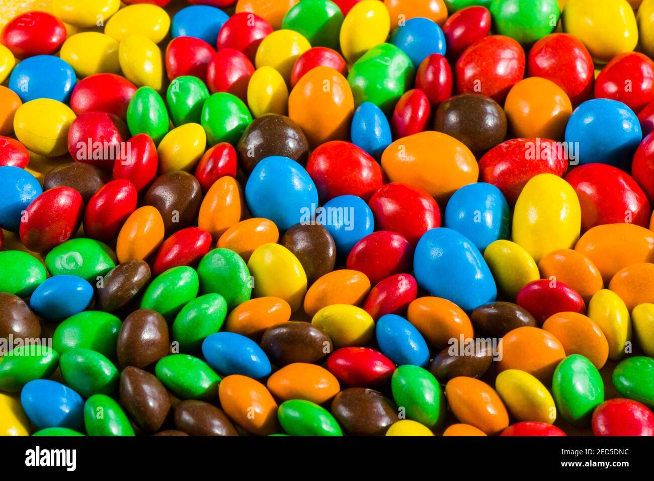 M&M's candy on the yellow background, colorful candy and multicolored ...