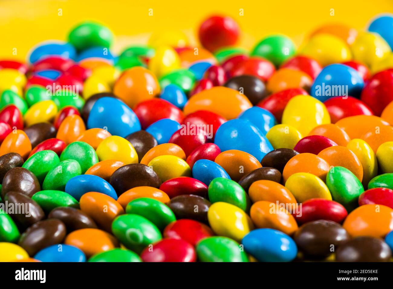 M&M's candy on the yellow background, colorful candy and multicolored ...