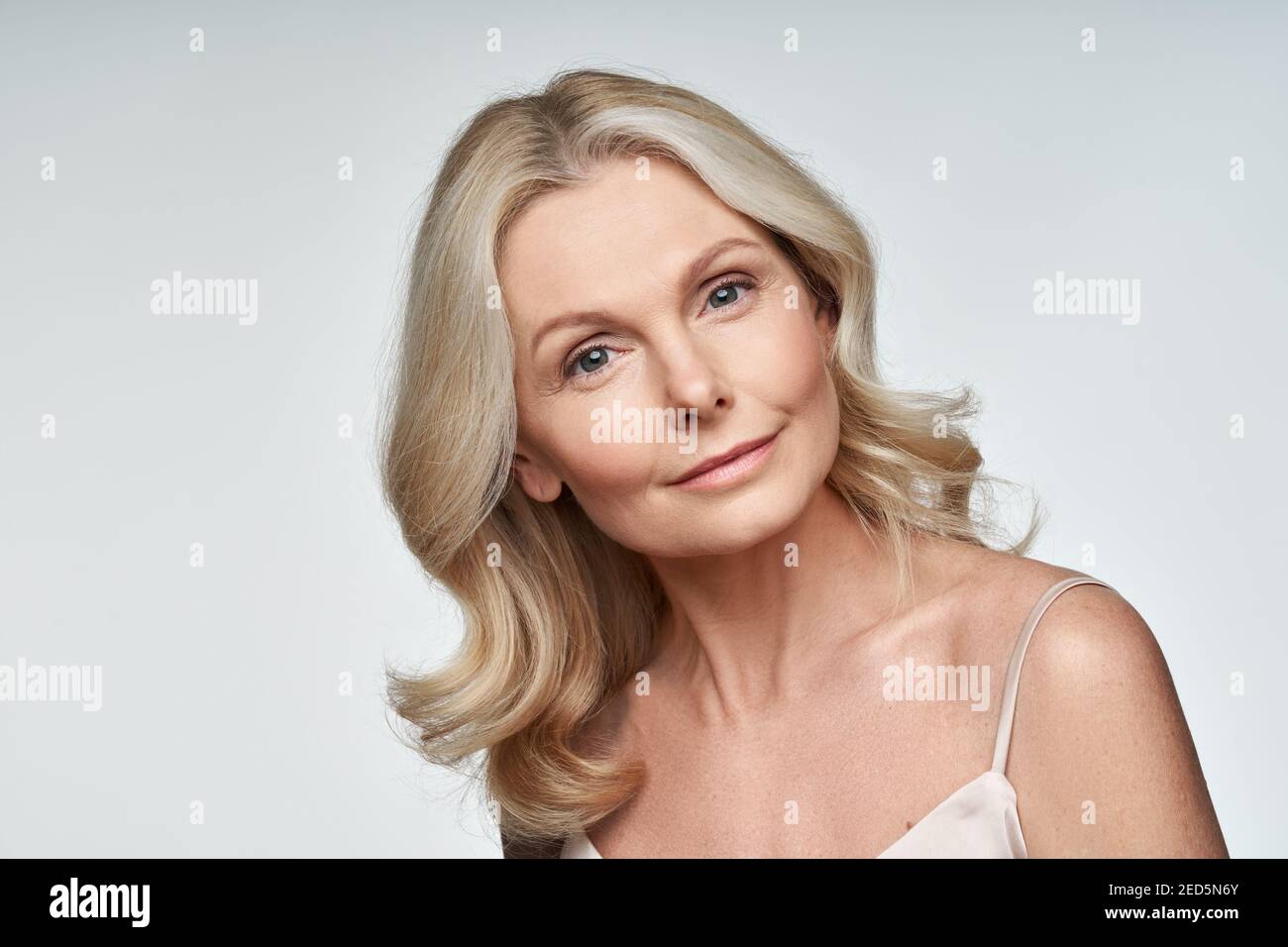 Beautiful 50s middle aged mature woman looking at camera isolated on white. Stock Photo