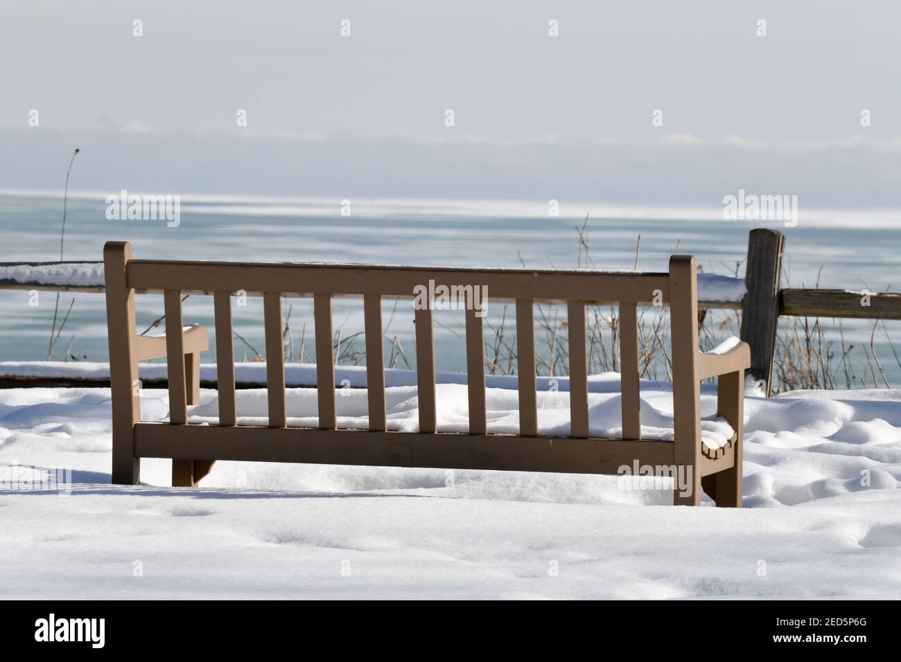 Empty park bench along the frozen winter lakeshore Stock Photo - Alamy