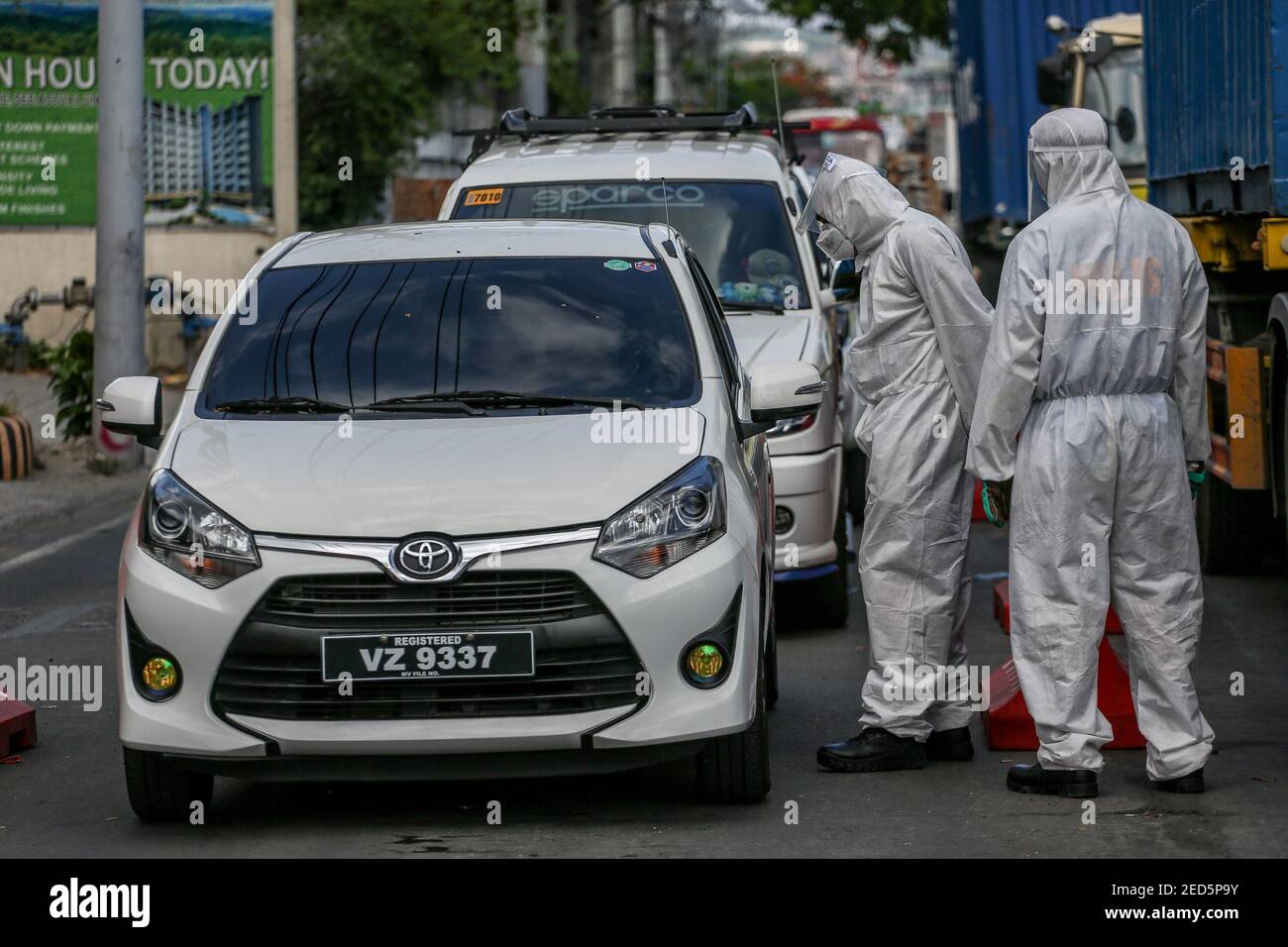 Filipino policemen wearing personal protective equipment (PPE) stop and