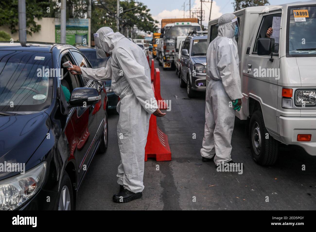 Filipino policemen wearing personal protective equipment (PPE) stop and