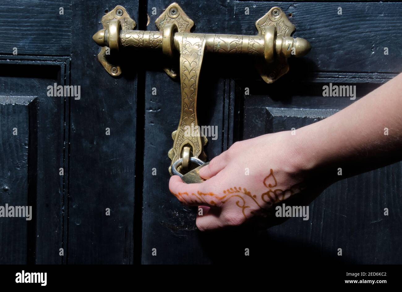 Girl hand with henna holding ornamental brass lock Stock Photo