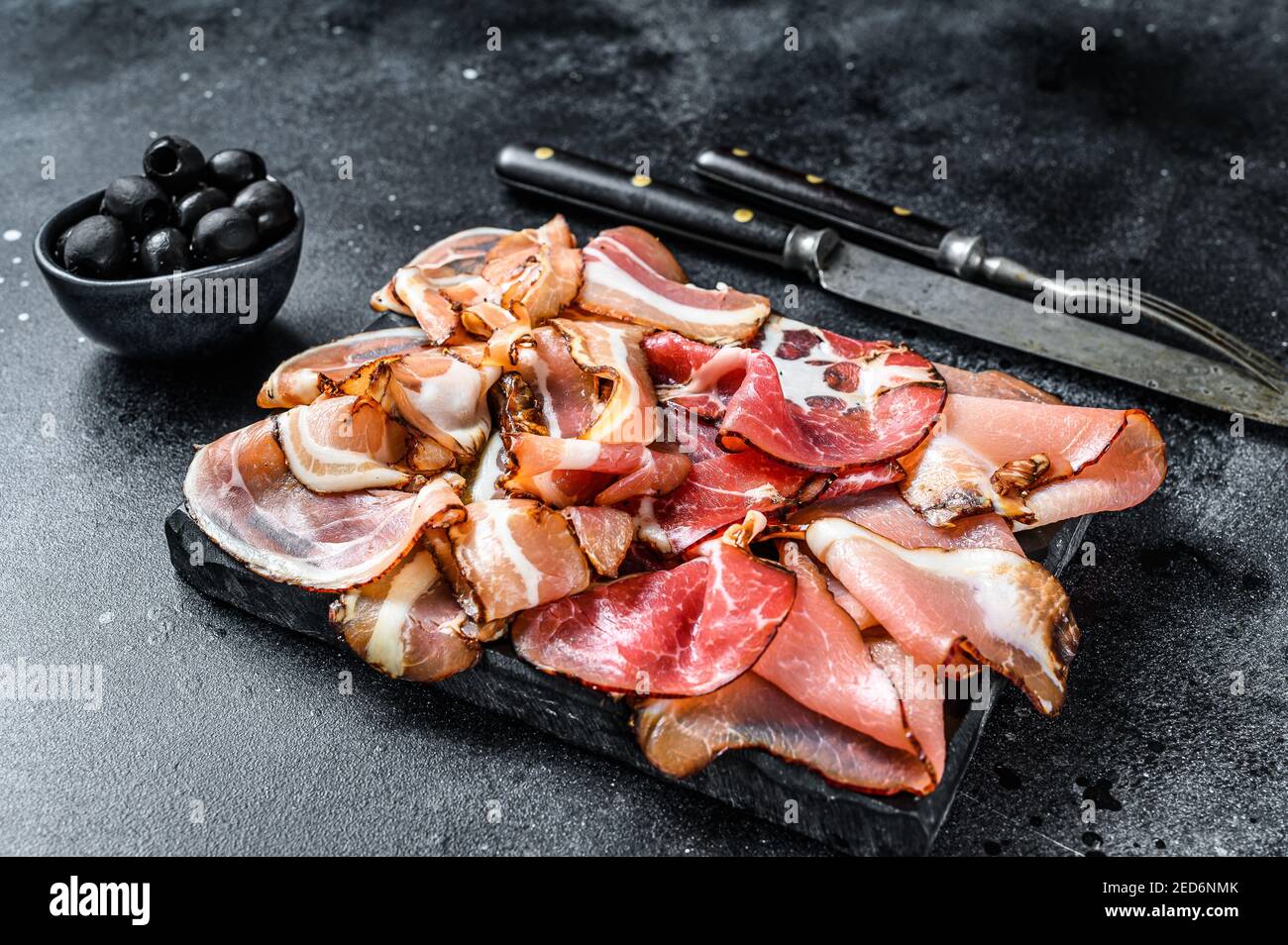 Set of cold cured italian meat Ham, prosciutto, pancetta, bacon. Black
