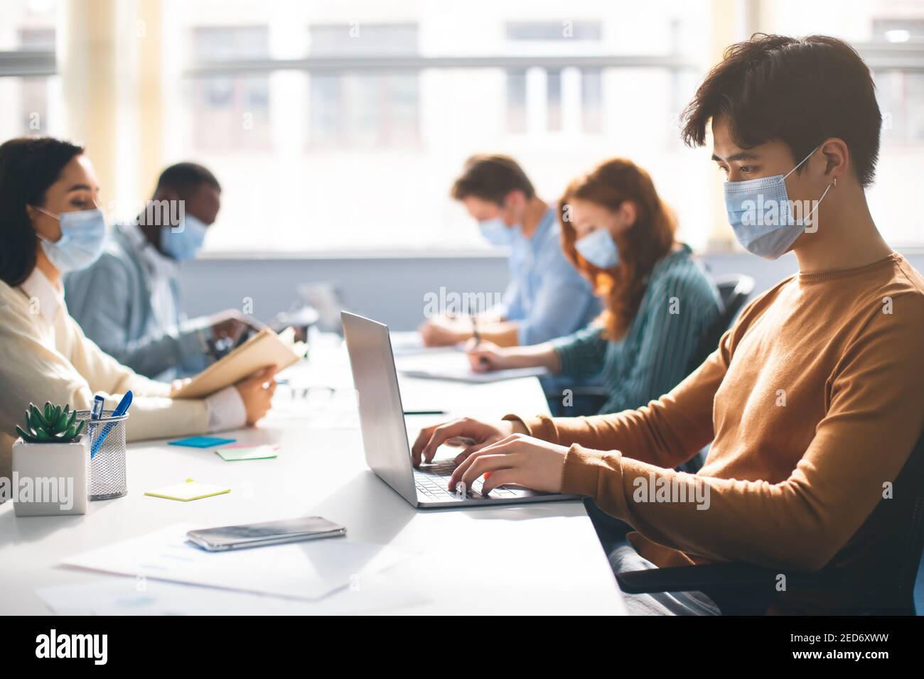 International people wearing medical masks using laptop Stock Photo - Alamy
