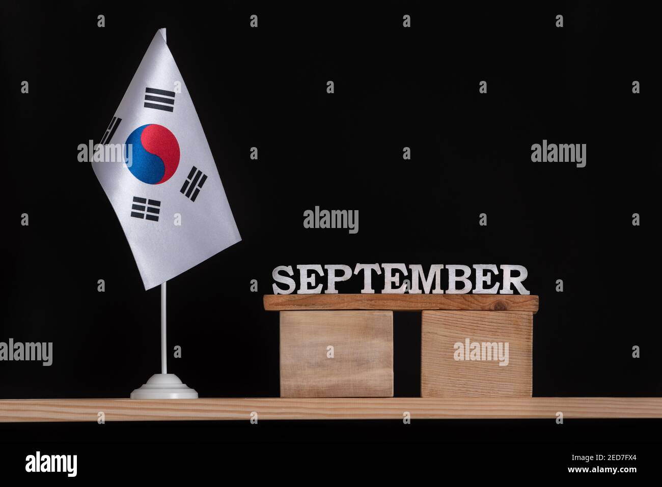 Wooden calendar of September with South Korea flag on black background