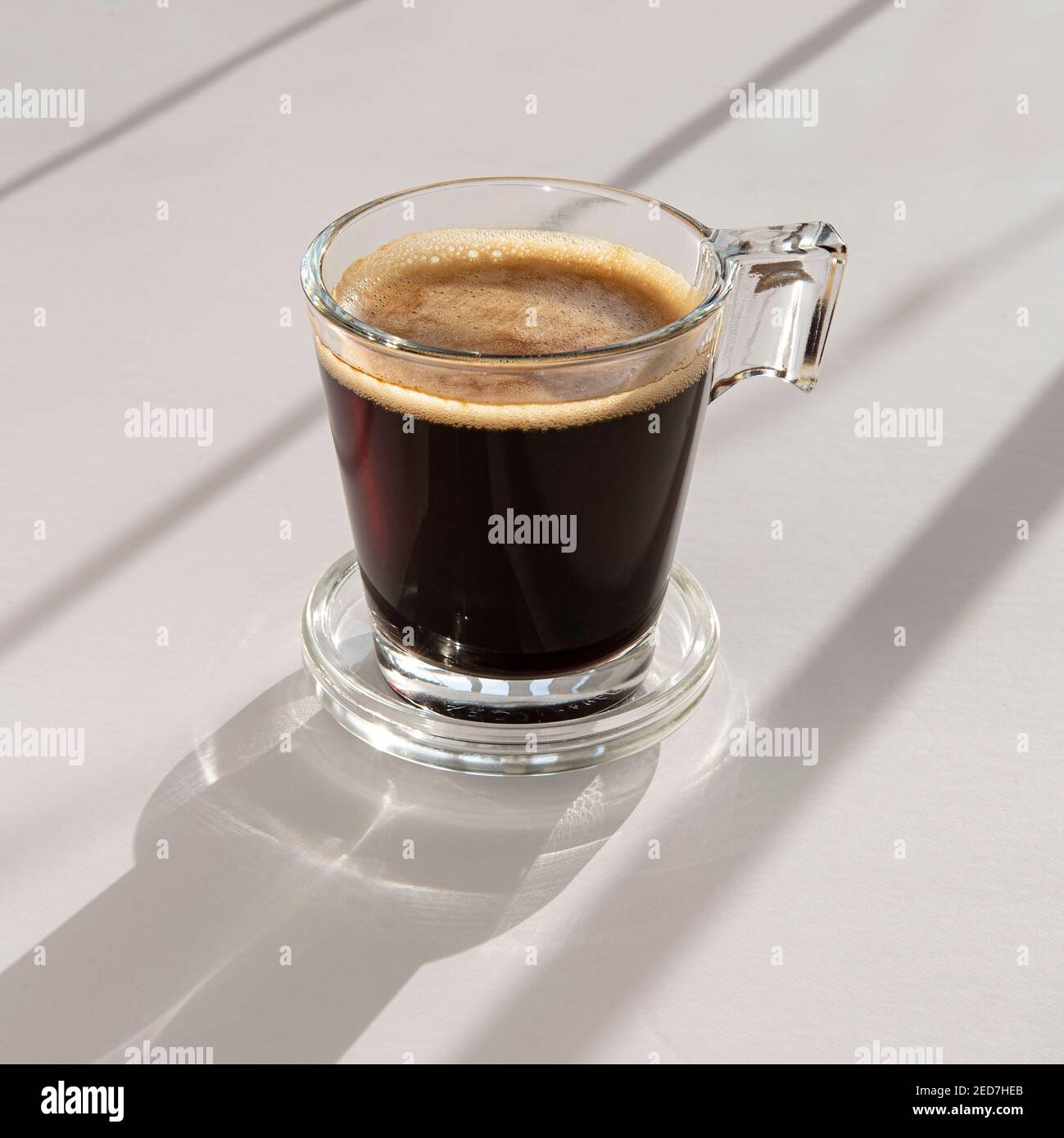 Black coffee in a glass cup and saucer Stock Photo