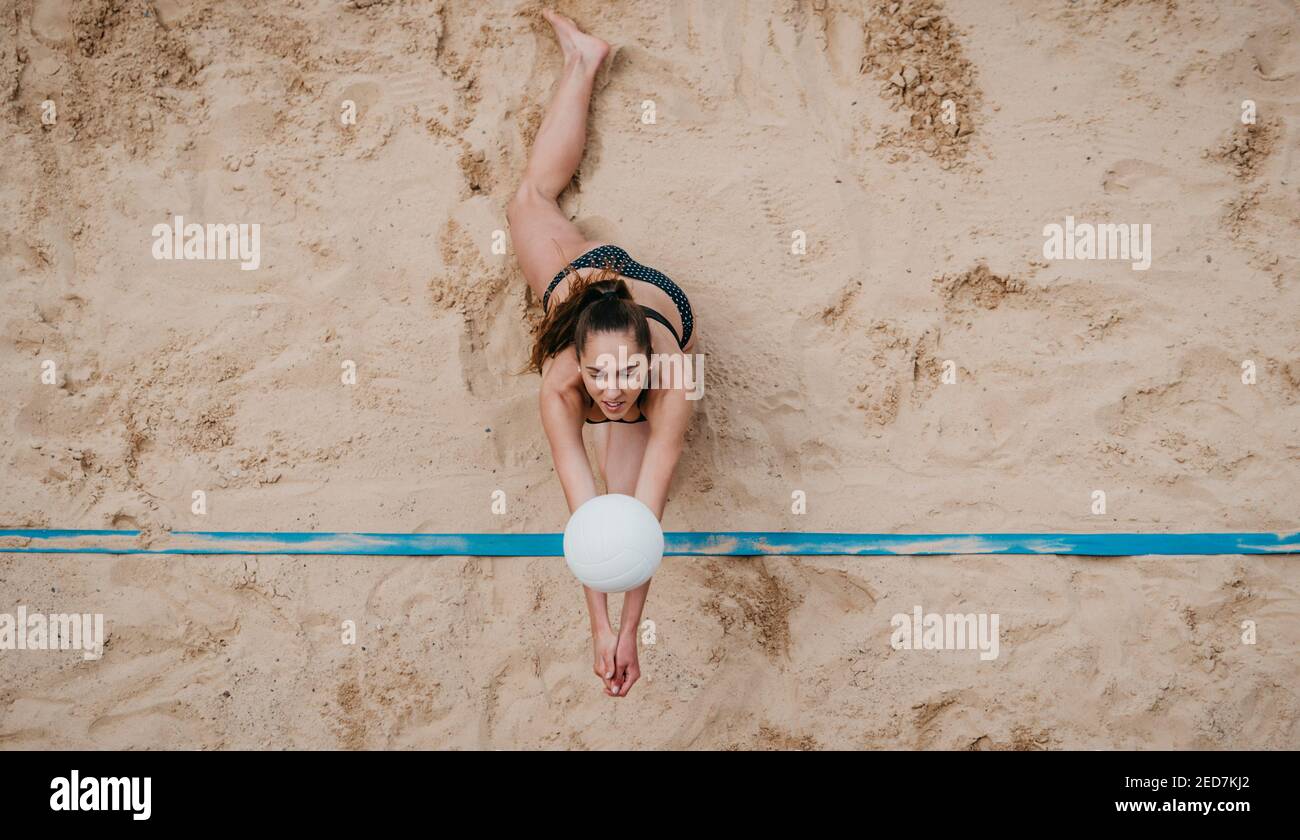 Professional player with white ball playing beach volleyball on sand. Summer vacation and sport concept Stock Photo