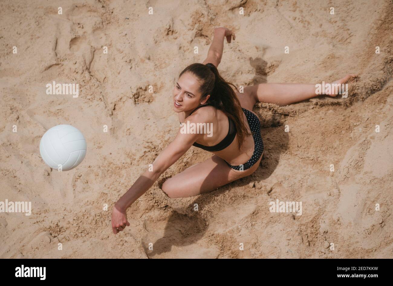 Professional player with white ball playing beach volleyball on sand. Summer vacation and sport concept Stock Photo