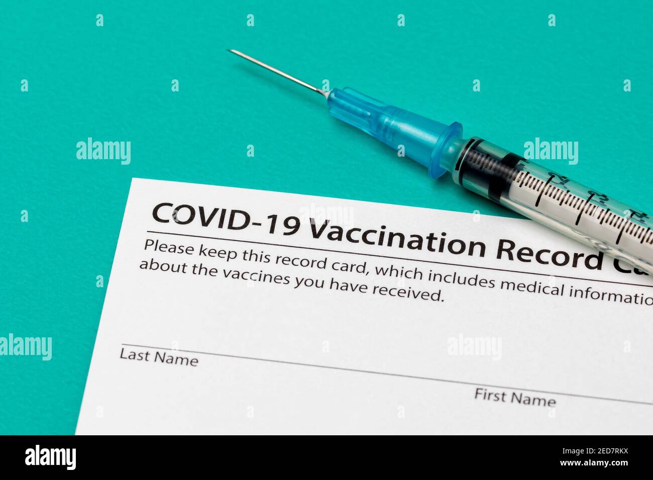Covid-19 coronavirus vaccination record card with syringe and needle. Concept of vaccination, herd immunity and pandemic healthcare. Stock Photo