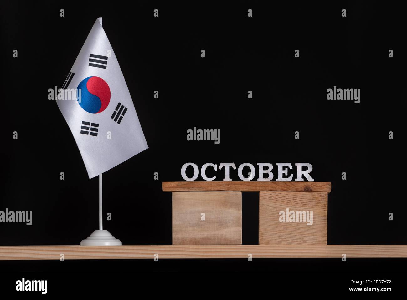 Wooden calendar of October with South Korea flag on black background