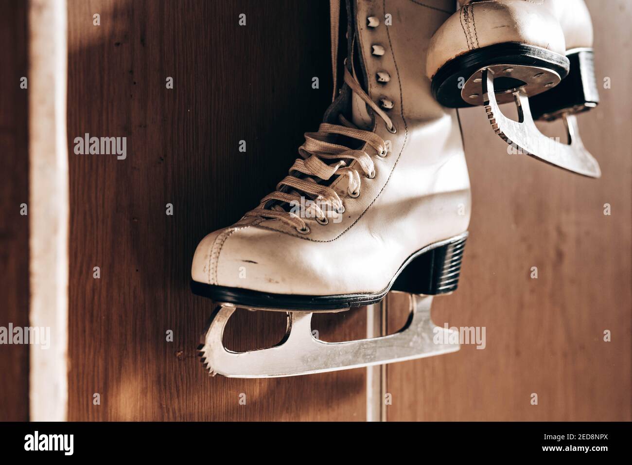 Old retro skates hanging on the wall Stock Photo