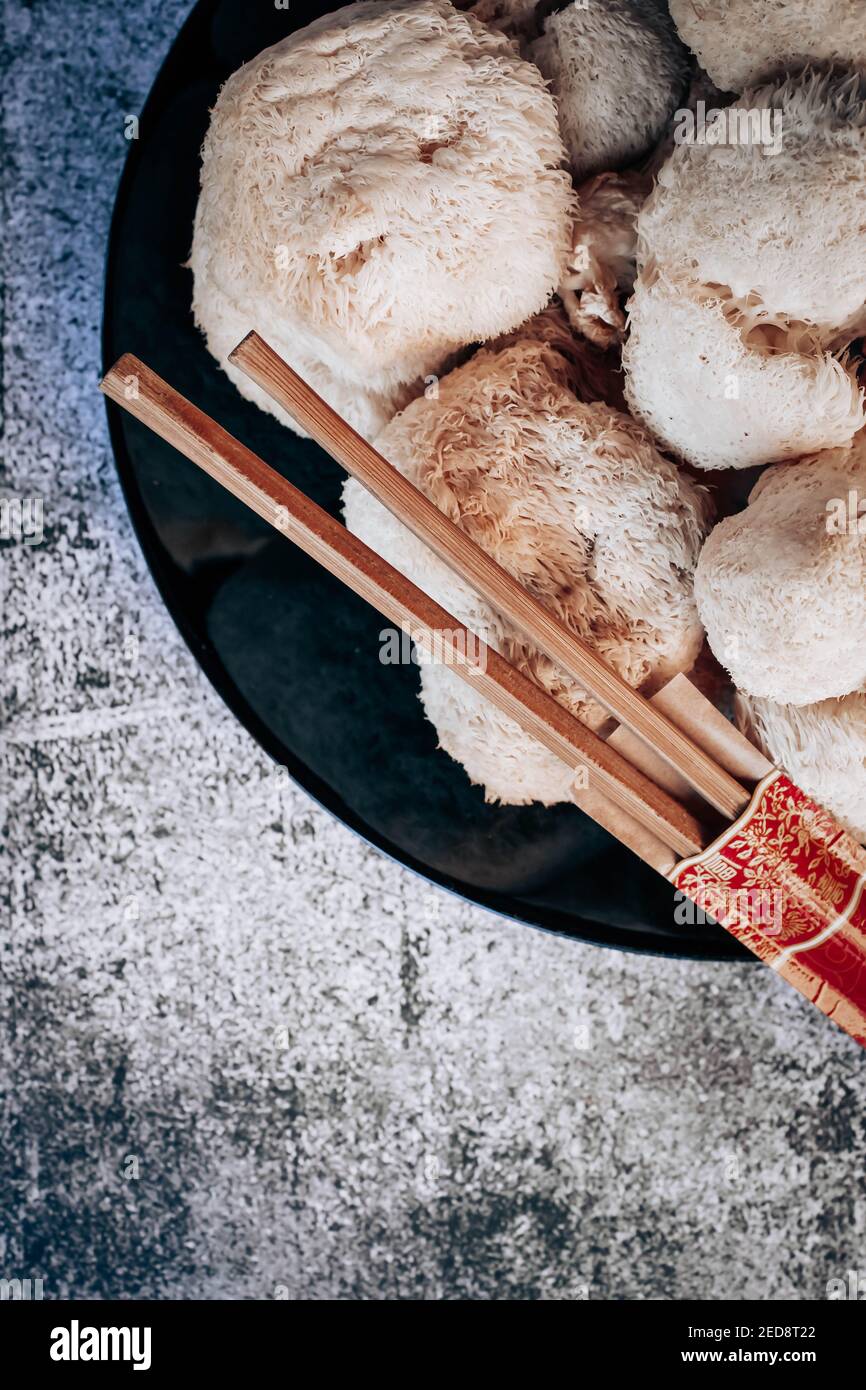 Top view of hericium erinaceus or Lions mane mushrooms on a plate with Chinese sticks. Medical mushroom concept Stock Photo