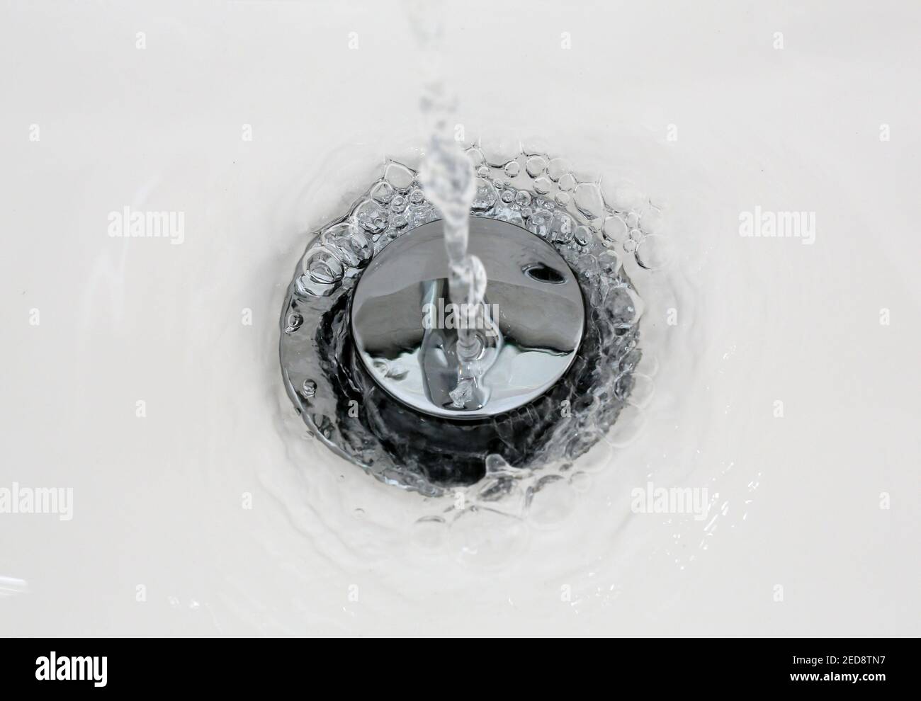 Water drain from the washbasin foaming in from the new clean bathroom Stock Photo