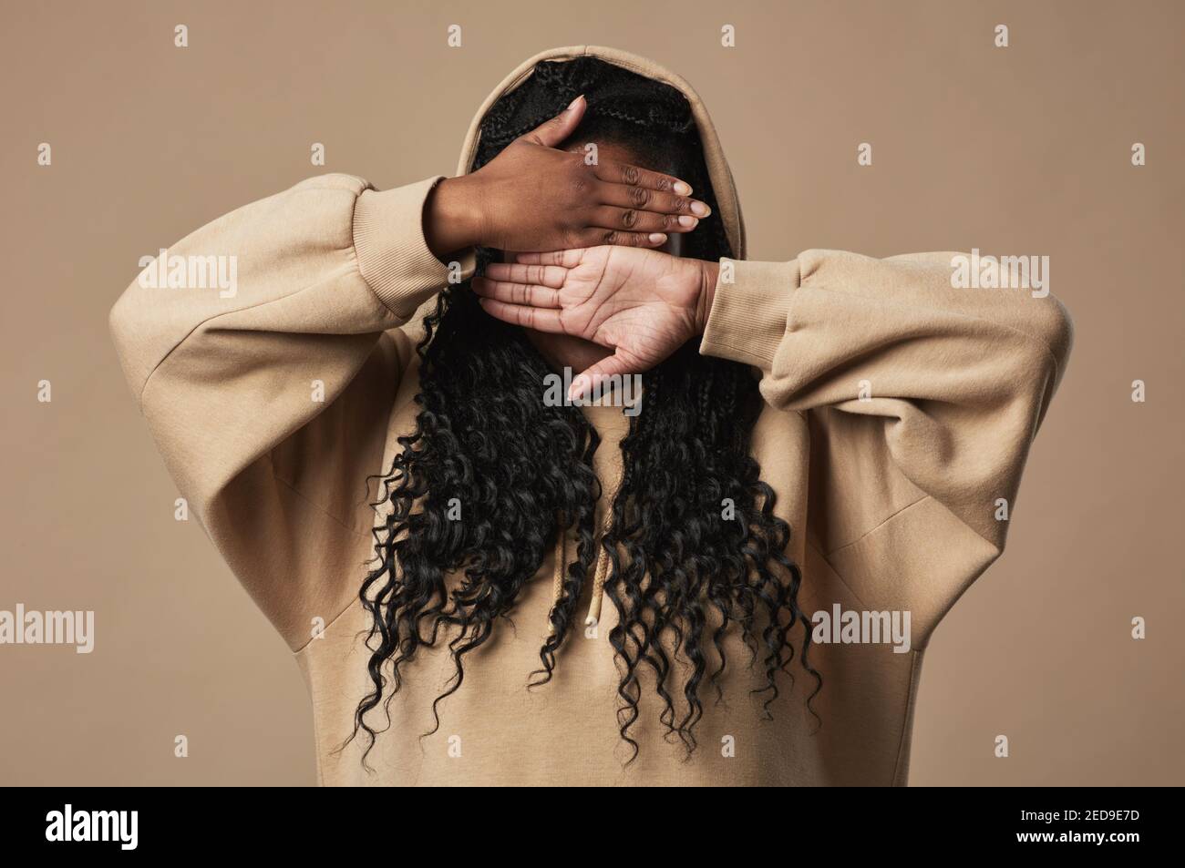 Minimal waist up portrait of young African American woman hiding face ...