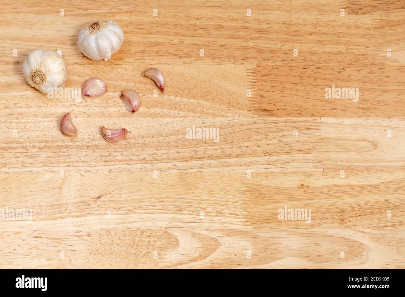 garlic and garlic cloves on a wooden table located in the upper left
